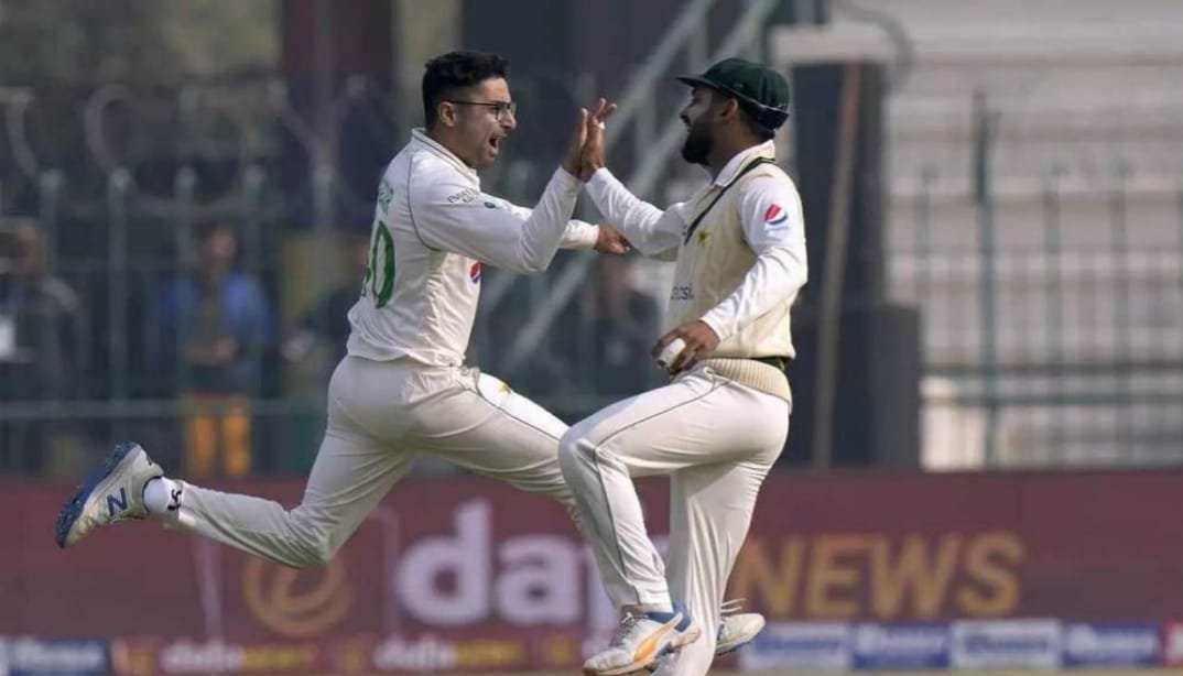 A team huddle featuring Abrar Ahmed and his teammates discussing bowling strategies.