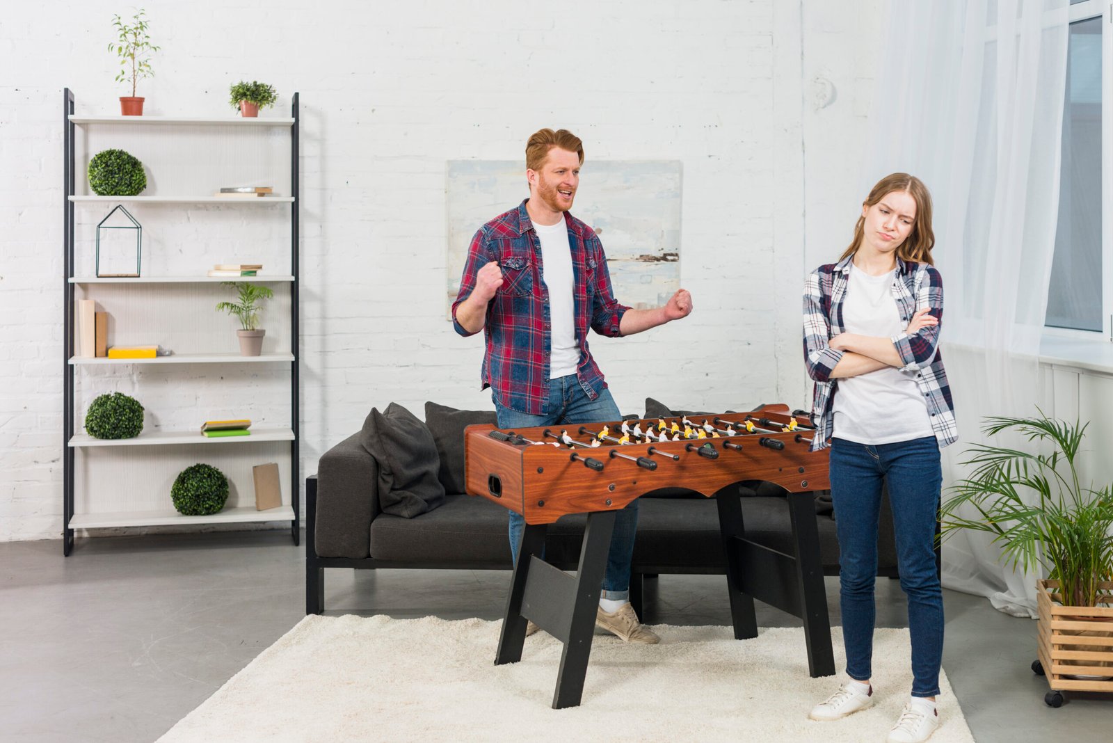 man-clenching-her-fist-with-joy-looking-sad-woman-modern-living-room-scaled
